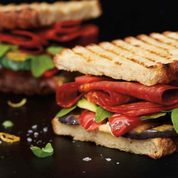 Chorizo sandwich with grilled vegetables, fresh basil, lemon hummus and arugula